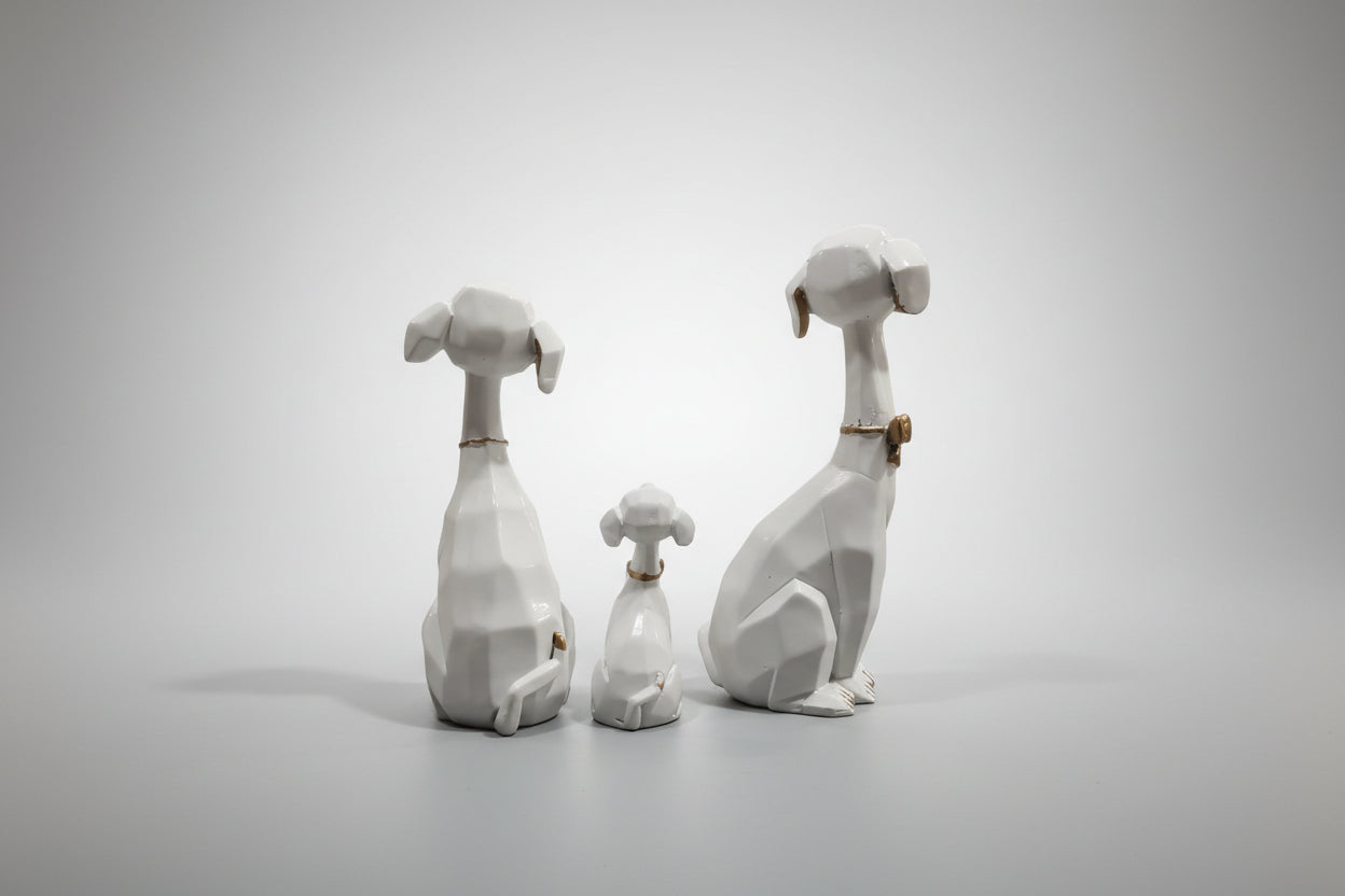 Three stone sculptures of dogs on a gray background