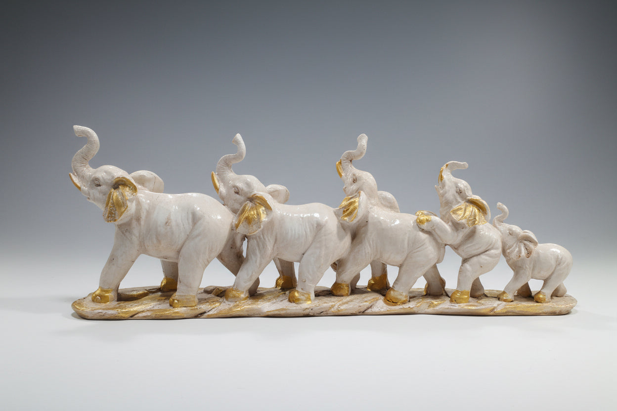 Decorative figurine of five elephants with gold accents on a white background