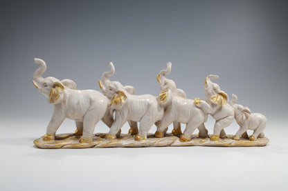 Decorative figurine of five elephants with gold accents on a white background