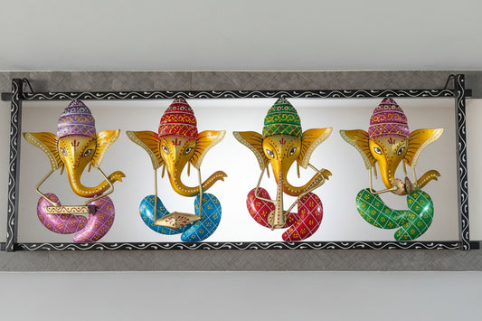 A metal wall decor featuring five figures of Lord Ganesha in different colors, each playing a different instrument.
