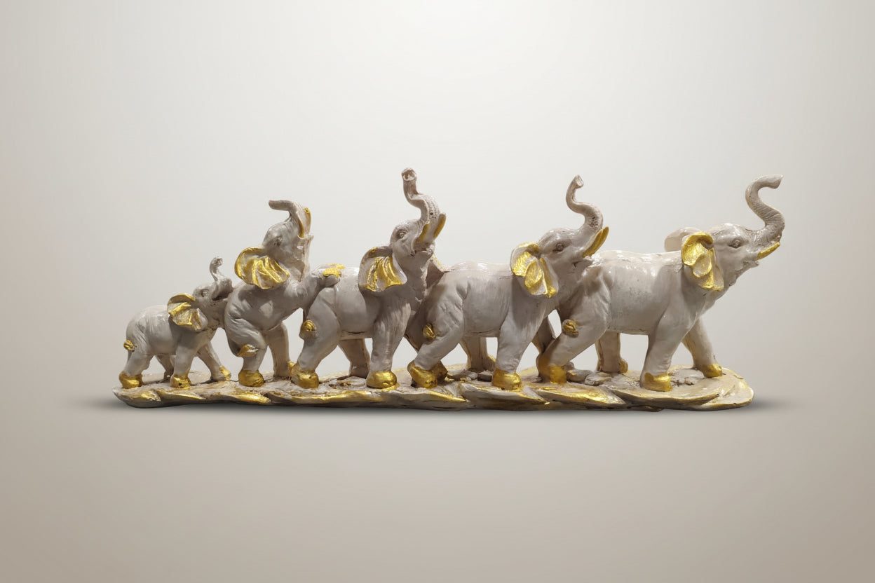 Decorative figurine of elephants with gold accents on a white background