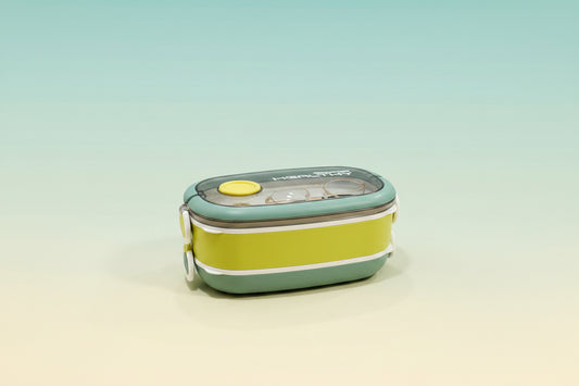 Green and yellow lunch box with a lid on a light green background