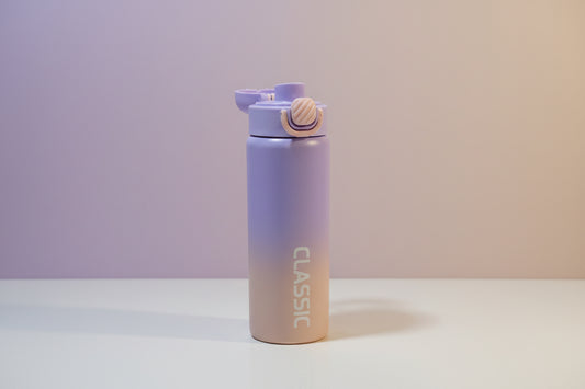 Gradient purple water bottle with a white cap on a white background