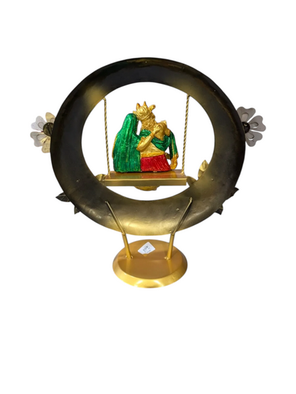Agiftshop Radha Krishna Jhula statue with gold and green figures on a swing, set within a black and gold circular frame.