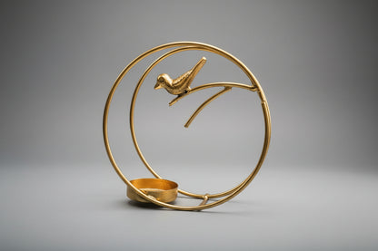 Decorative gold metal sculpture of a bird on a branch with a circular frame.