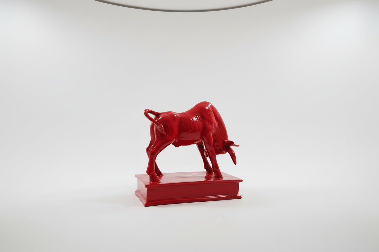 Red ceramic bull figurine on a white background