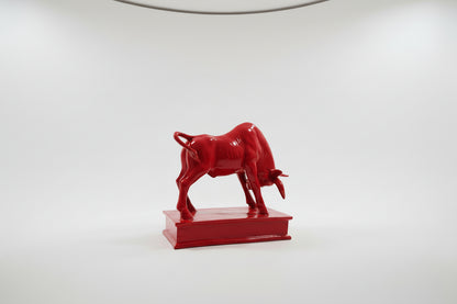 Red ceramic bull figurine on a white background