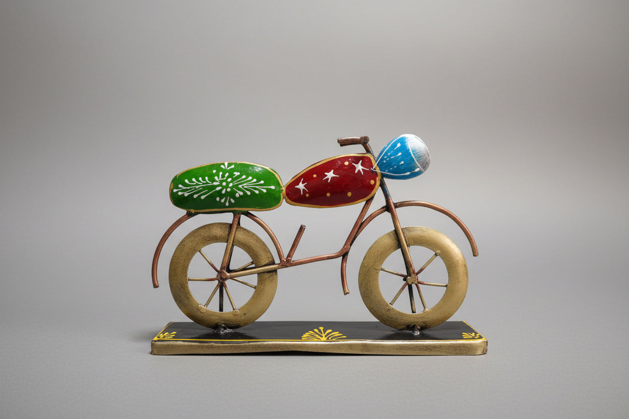 A decorative metal bike table top with a bronze frame, green seat, and blue handlebars on a white background.