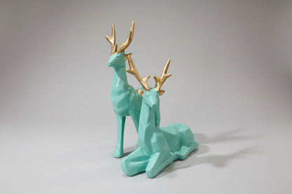 Two turquoise deer figurines with gold antlers on a white background