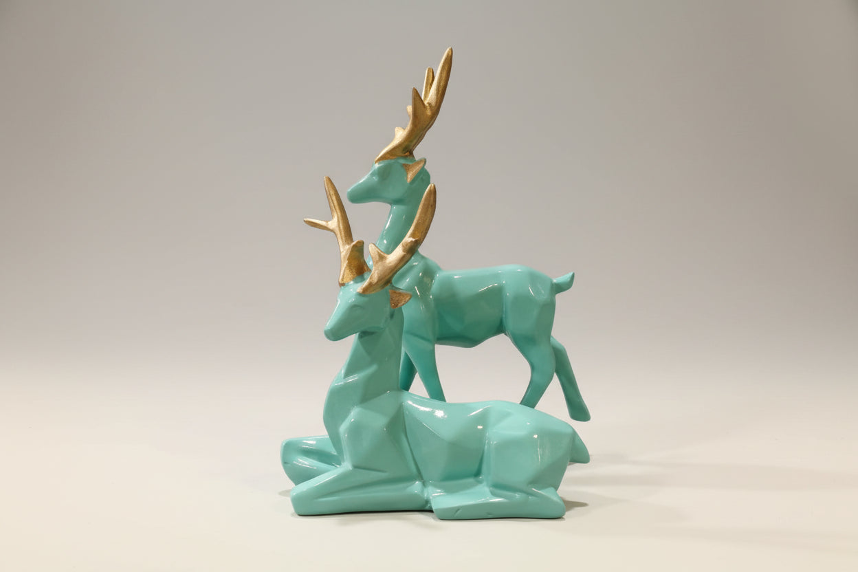 Turquoise ceramic deer figurines with gold accents on a white background
