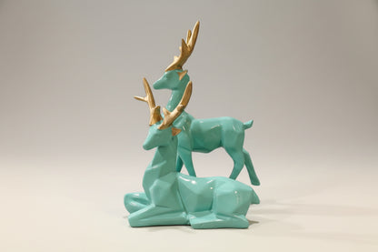 Turquoise ceramic deer figurines with gold accents on a white background