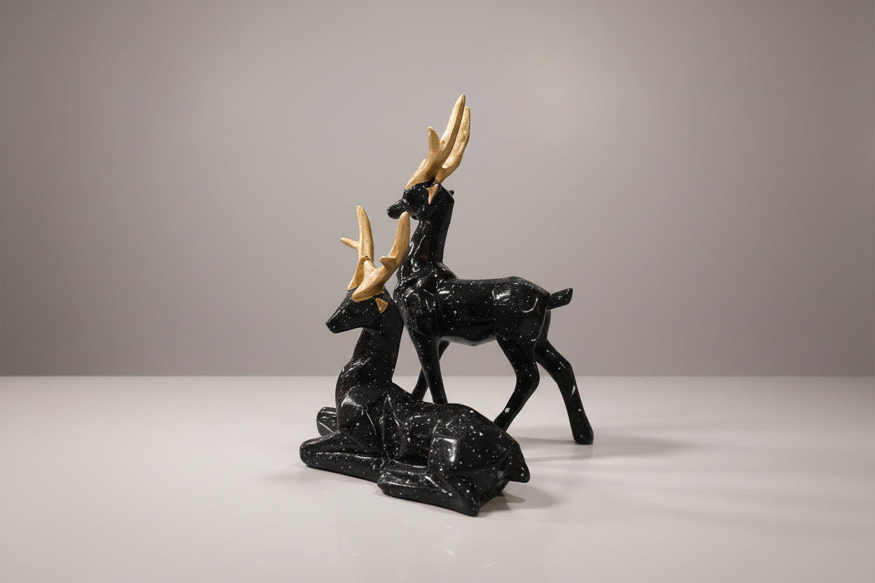 Black stone carvings of deer on a white background