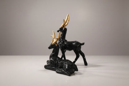 Black stone carvings of deer on a white background