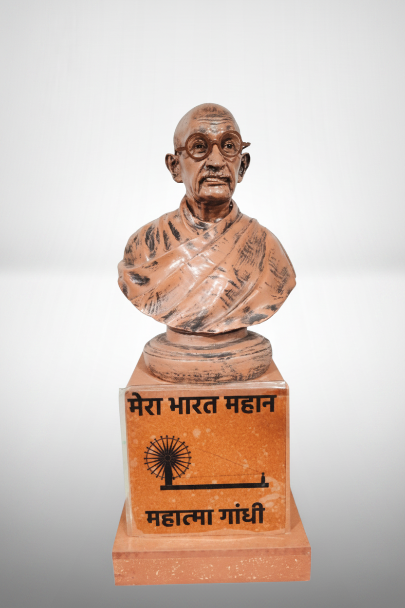 A resin showpiece statue of Mahatma Gandhi with a beige and dark brown finish, standing on a base with a plaque in Devanagari script.