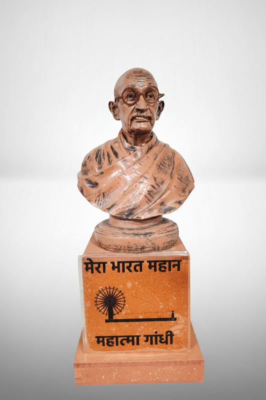 A resin showpiece statue of Mahatma Gandhi with a beige and dark brown finish, standing on a base with a plaque in Devanagari script.