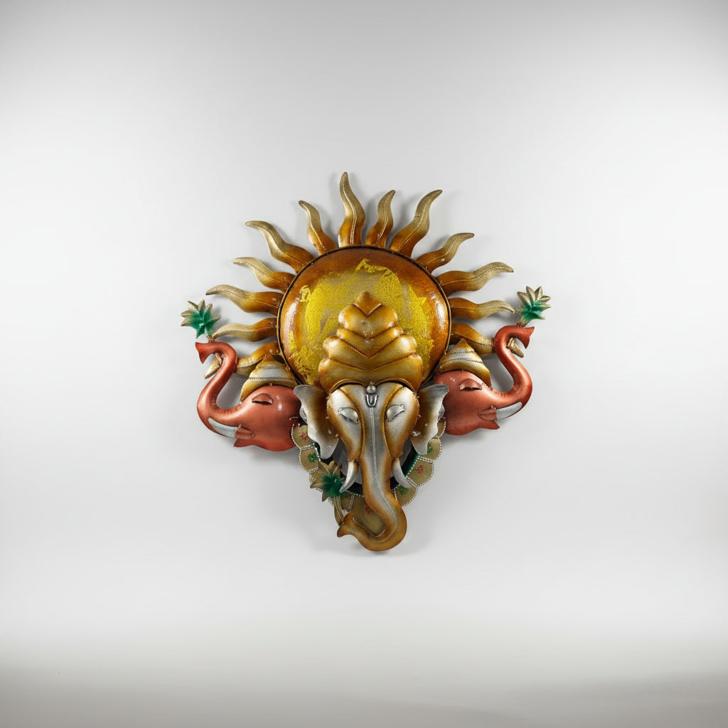 A metal idol of Lord Ganesh featuring a sun pattern with two elephant hands on the sides.