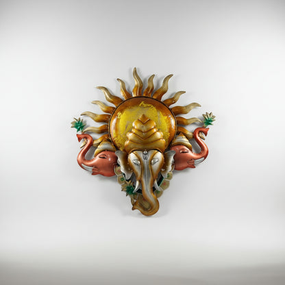 A metal idol of Lord Ganesh featuring a sun pattern with two elephant hands on the sides.
