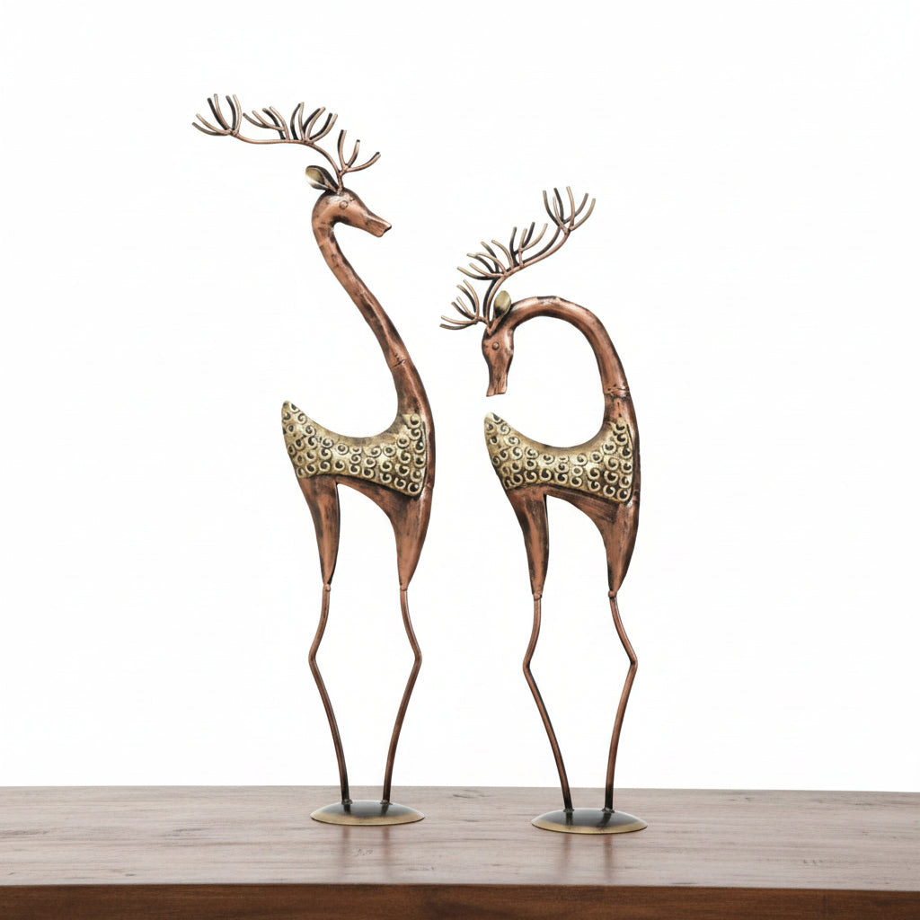 Two decorative deer figures with multicolored finish, placed on a table.