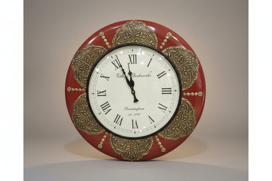 Decorative wall clock with red and gold design on a white background