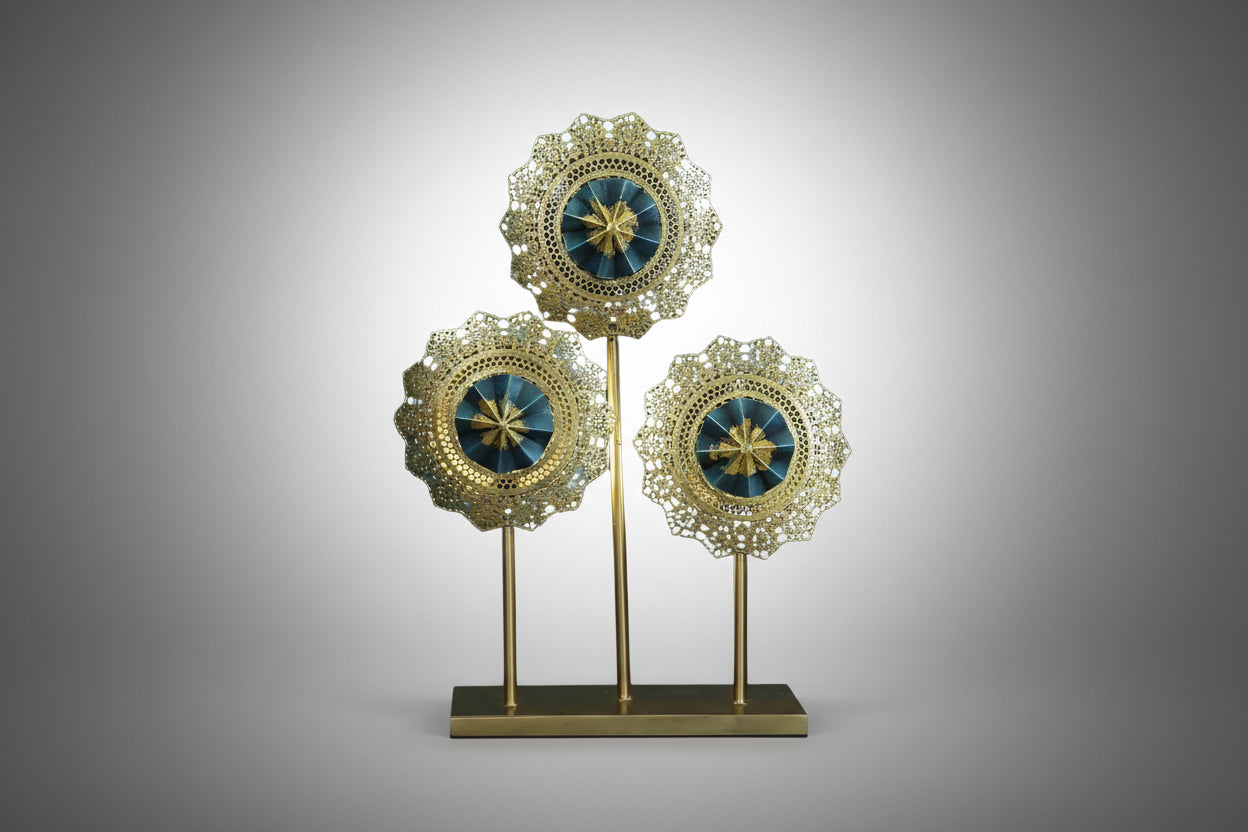 A set of three round metal decorative pieces mounted on a wall, with gold-colored edges and blue-colored centers.