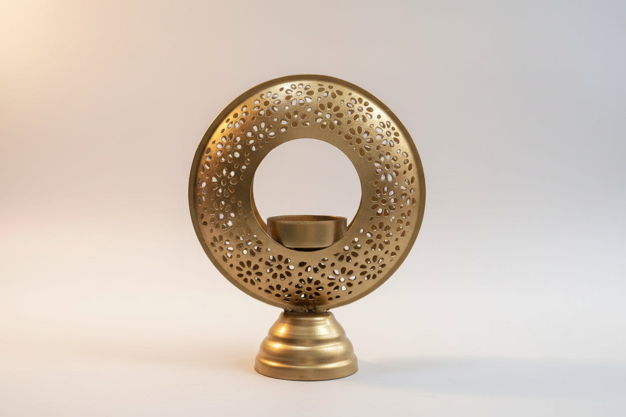 Decorative gold candle holder with intricate design on a white background