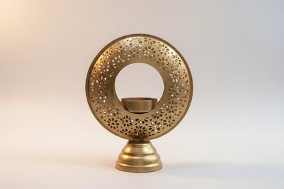 Decorative gold candle holder with intricate design on a white background