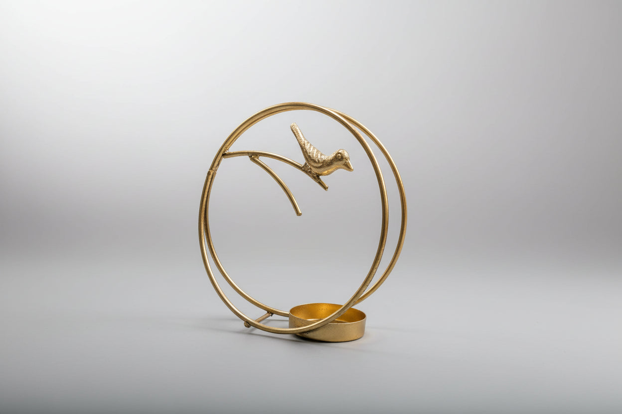 Decorative gold sculpture of a bird on a branch with a circular design