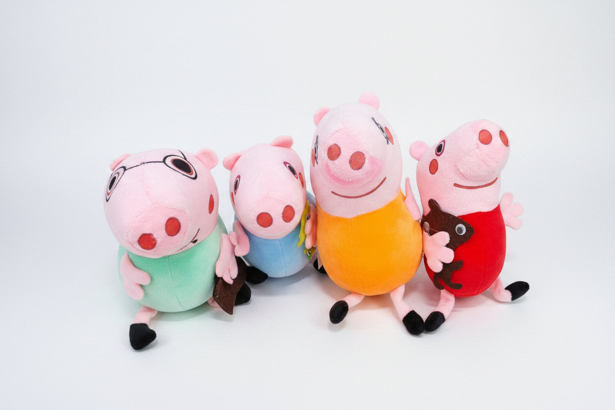 A set of Peppa Pig family soft toys, including characters Peppa, George, Mummy, and Daddy Pig, seated together.