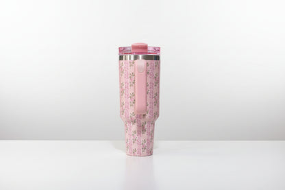 Pink tumbler with floral pattern on a white background