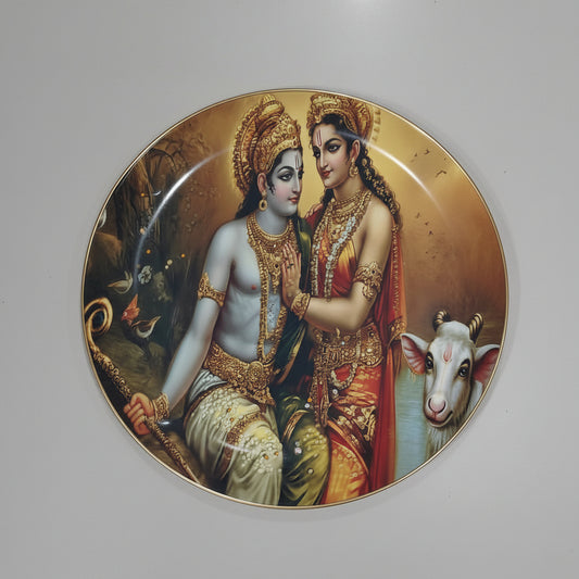 A decorative wall plate featuring artistic representations of Radha and Krishna, along with a cow, in vibrant colors with floral and celestial motifs.
