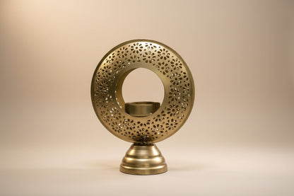Decorative brass candle holder with intricate design on a white background