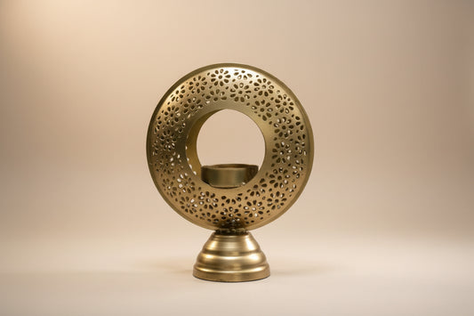 Decorative brass candle holder with intricate design on a white background