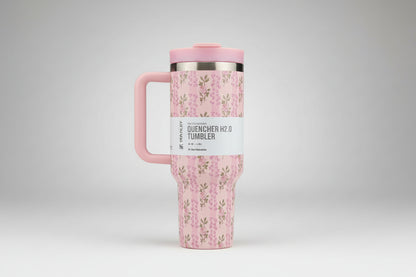 Pink floral-patterned tumbler with a handle on a white background