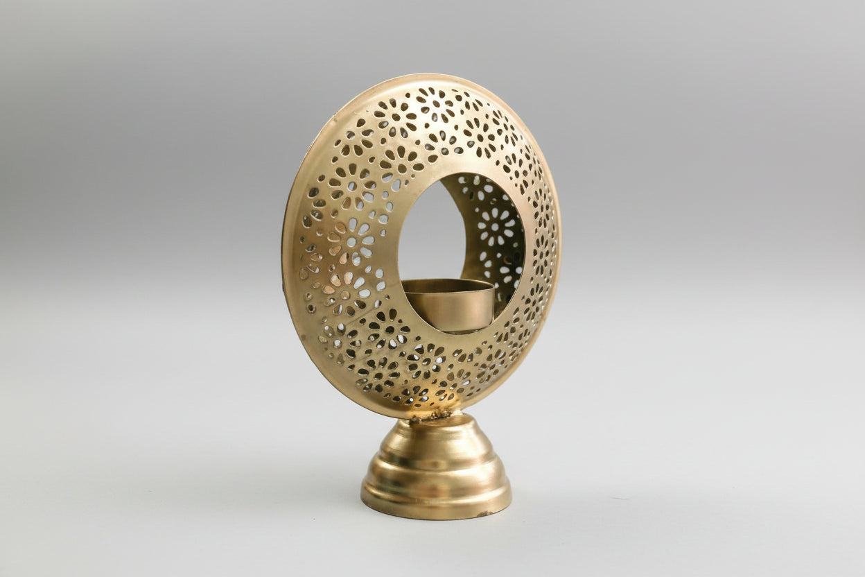 Decorative gold candle holder with intricate design on a white background