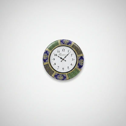 A wall clock with a handcrafted floral design, featuring a white clock face with black numerals, placed above a white sofa in a bright room.