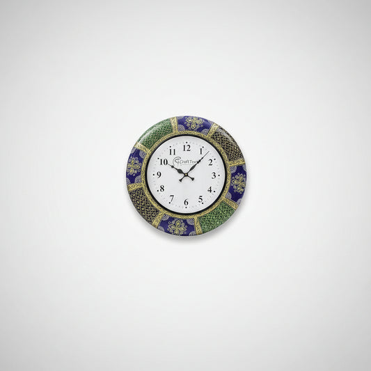 A wall clock with a handcrafted floral design, featuring a white clock face with black numerals, placed above a white sofa in a bright room.