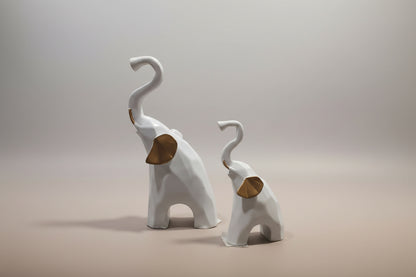 Two white elephant figurines with brown trunks on a light gray background