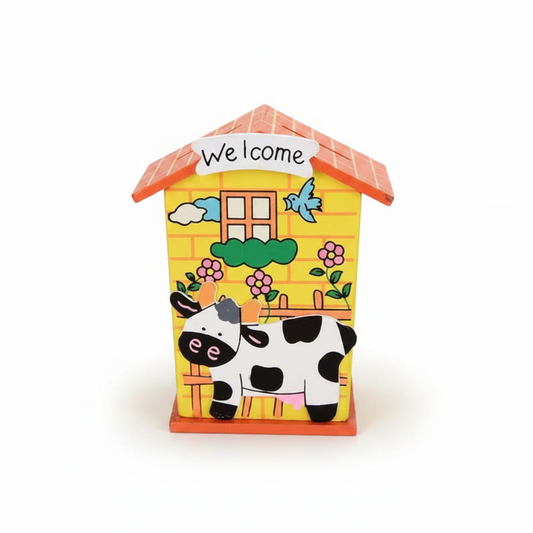 A colorful wooden house-shaped piggy bank with a cow cut-out on the front and a coin slot on the roof.